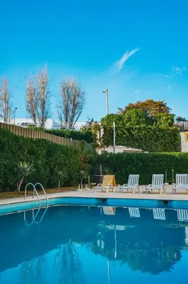 a swimming pool with white chairs and a fence at Eirasol by Umbral in Albufeira