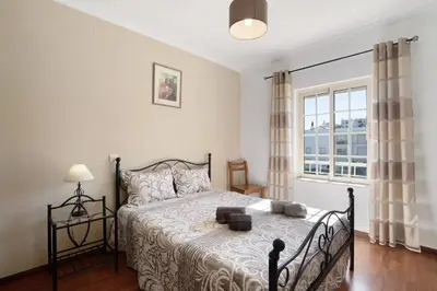 a bedroom with a bed and a large window at Golden Rana Apartment in Albufeira