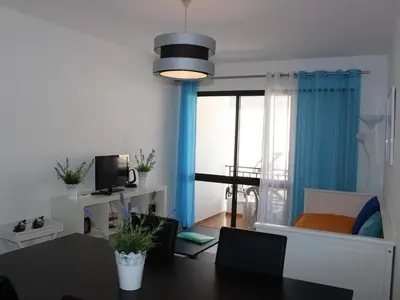 a living room with a table and a room with a bedroom at Albufeira Apartments in Albufeira