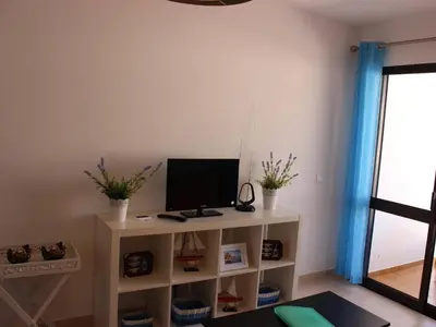 a living room with a tv on a white shelf at Albufeira Apartments in Albufeira
