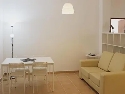 a living room with a table and a couch at Albufeira Apartments in Albufeira