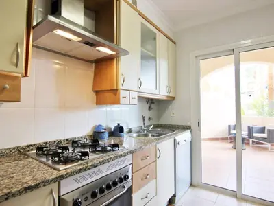 a kitchen with a stove and a sink at Los Arcos Apartment I in Vilamoura