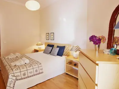 a bedroom with a bed and a desk with flowers at Los Arcos Apartment I in Vilamoura