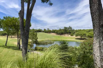 a golf course with a pond and trees at Marina Vilamoura - Aquamar 209 - By Vilamoura Sun in Vilamoura