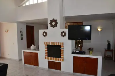 a living room with a flat screen tv on a wall at Villa Batista in Guia