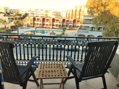 two chairs on a balcony with a view of a city at Excelente T1 Oura Beach Bicos Apartment Lucia in Albufeira