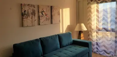 a blue couch in a living room with paintings on the wall at The Market Square House in Faro
