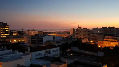 a view of a city skyline at sunset at The Market Square House in Faro