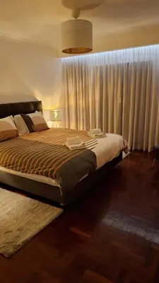 a bedroom with a large bed with a large window at The Market Square House in Faro