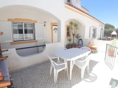 a white patio with a white table and chairs at Casa Sol da Falesia in Albufeira