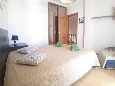 a bedroom with a bed with two green towels on it at Casa Sol da Falesia in Albufeira