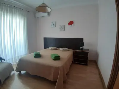 a bedroom with a bed with two green towels on it at Casa Sol da Falesia in Albufeira