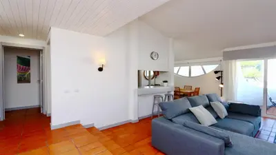 a living room with a blue couch and a kitchen at Palmeiras do Golfe 160 - Clever Details in Vilamoura