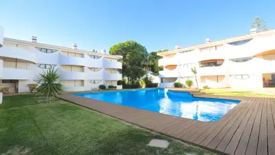 an apartment with a swimming pool in front of a building at Palmeiras do Golfe 160 - Clever Details in Vilamoura