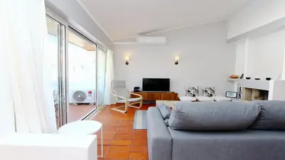 a living room with a couch and a tv at Palmeiras do Golfe 160 - Clever Details in Vilamoura