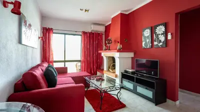 a red living room with a couch and a tv at ★ Sea View ★ 1 Minute to Oldtown and Beach ★ in Albufeira