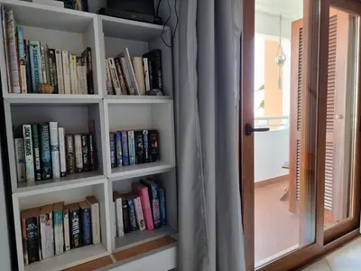a book shelf filled with books next to a door at MAIN AVENUE ALBUFEIRA, walk to beach, Old Town, shooping, top location in Albufeira