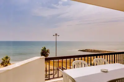 a balcony with a table and chairs and the ocean at Atlântico View - Beach front - Quarteira in Quarteira