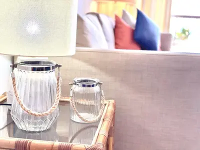 a glass vase on a glass table with a lamp at Atlântico View - Beach front - Quarteira in Quarteira