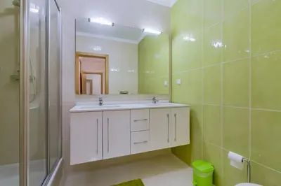 a bathroom with a sink and a shower and a mirror at Forte Novo - Modern apartment - Quarteira in Quarteira
