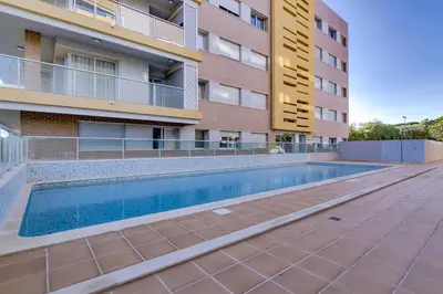 a swimming pool in front of a building at Forte Novo - Modern apartment - Quarteira in Quarteira