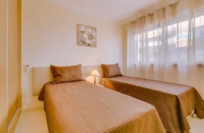 two beds in a room with a window at Forte Novo - Modern apartment - Quarteira in Quarteira