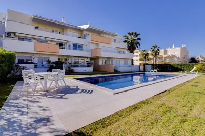a villa with a swimming pool in front of a building at Ribas - Cozy 2 bedroom apartment - Vilamoura in Vilamoura