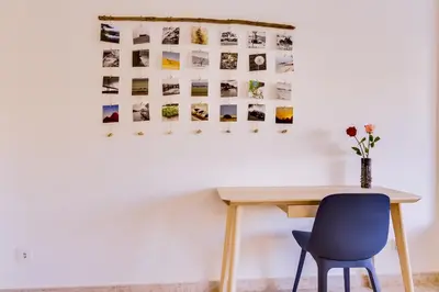 a table and a chair next to a wall with photos at Ribas - Cozy 2 bedroom apartment - Vilamoura in Vilamoura