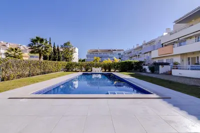 a swimming pool in a yard next to a building at Ribas - Cozy 2 bedroom apartment - Vilamoura in Vilamoura