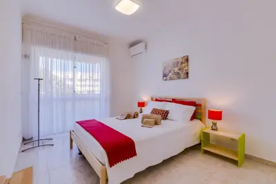 a white bedroom with a large bed and a window at Ribas - Cozy 2 bedroom apartment - Vilamoura in Vilamoura