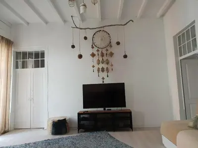 a living room with a flat screen tv on a white wall at Old Charming House Faro in Faro