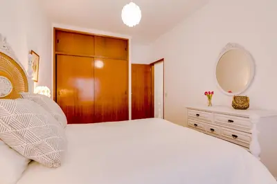 a bedroom with a white bed and a mirror at Casa da Esquina - Faro city center in Faro