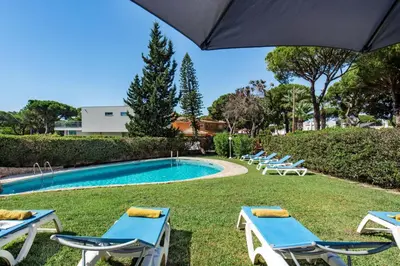 a pool with a waterfall and a house at 5 En-Suite Bedrooms, close to centre, free AC WiFi in Loulé