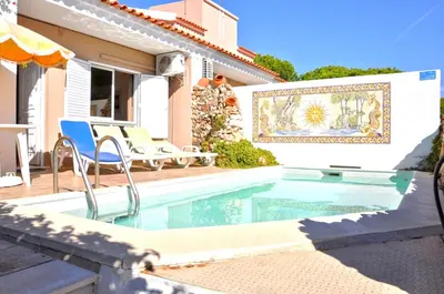 a bedroom with a bed and a desk and a mirror at Stylish and well-equipped, private pool, close to amenities, free AC and Wifi in Quarteira
