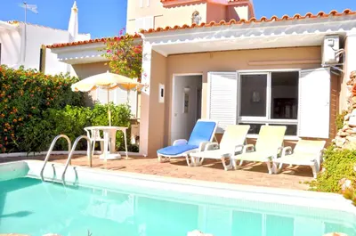 a living room with a table and a dining room at Stylish and well-equipped, private pool, close to amenities, free AC and Wifi in Quarteira