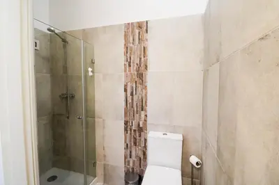 a bathroom with a toilet and a glass shower at Casa Moura Golfe in Vilamoura