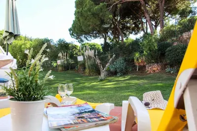 a table with a book and a glass of wine at Casa Moura Golfe in Vilamoura