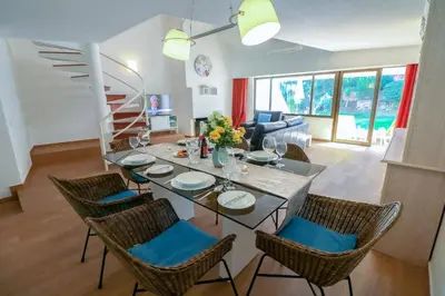 a living room with a couch and a table with chairs at Casa Moura Golfe in Vilamoura