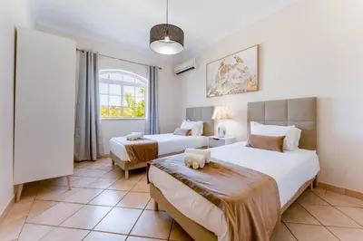 a bedroom with two beds and a window at Quinta das Laranjeiras in Boliqueime