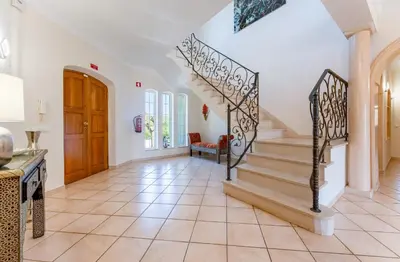 a staircase in a home with white walls and tile floors at Quinta das Laranjeiras in Boliqueime