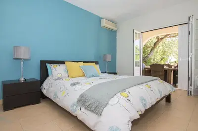 a bedroom with a large bed with blue walls at Villa Caravela in Almancil
