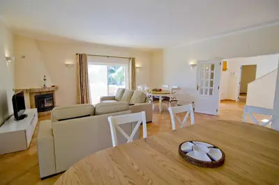 a living room with a couch and a table at Villa Jasmim in Almancil