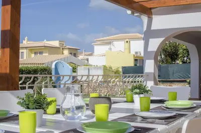 a patio with a table and chairs and a wooden pergola at Villa Magali in Galé