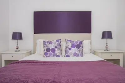 a bedroom with a purple bed with two lamps at Villa Magali in Galé