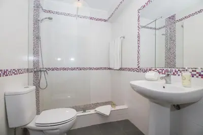a white bathroom with a toilet and a sink at Villa Magali in Galé