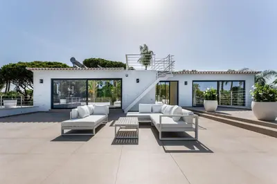 a patio with couches and tables on a building at Villa Natura in Vilamoura