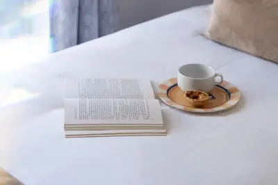 a book and a cup of coffee on a table at Casa Clara in Vilamoura