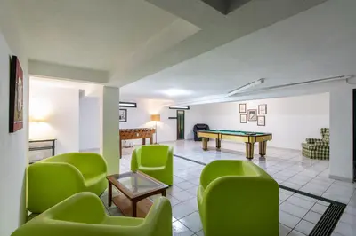 a living room with a ping pong table and green chairs at Casa Clara in Vilamoura
