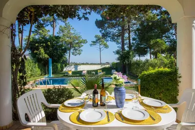 a table with plates and bottles of wine on a patio at Casa Clara in Vilamoura