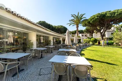 a villa with two blue chairs in the yard at Apartments Maria - Balaia 702 in Albufeira
